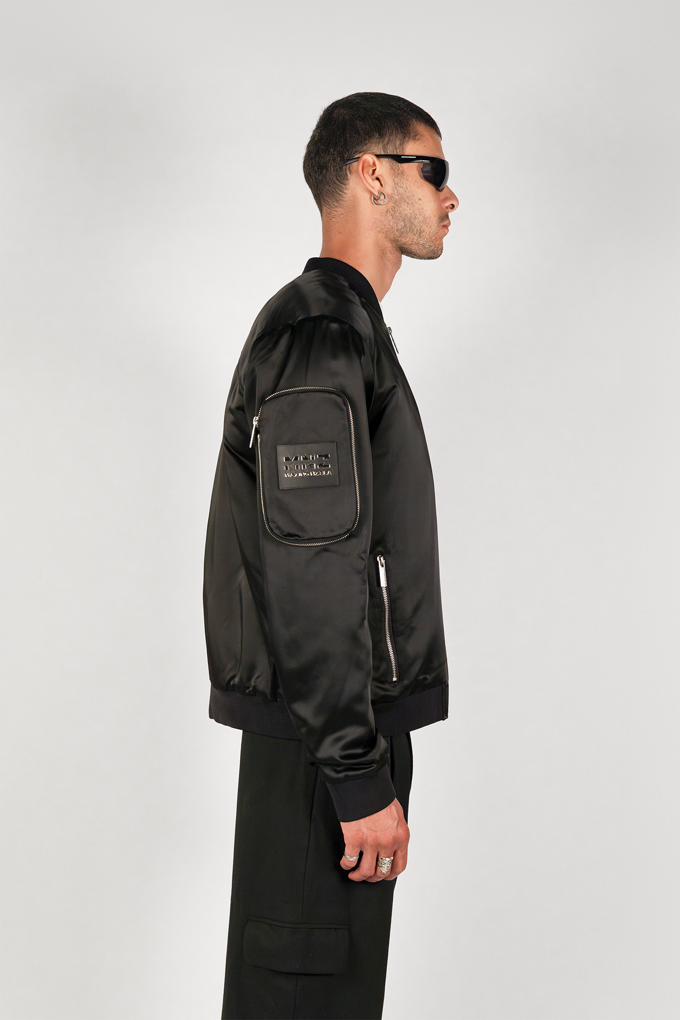 Men's bomber jacket with 3D cargo pockets, convertible crossbody bag, modular streetwear design, versatile and functional.